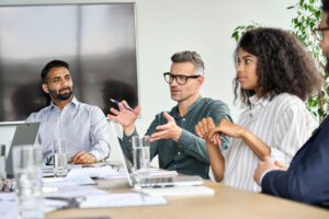 a group of people sit around a meeting table and talk about consulting services